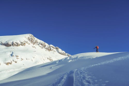 Unrecognizable skier riding snowy mountain ridge