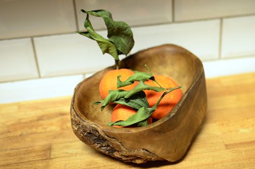 Free Fresh oranges with green leaves in a wooden bowl on a wooden surface, perfect for rustic kitchen themes. Stock Photo