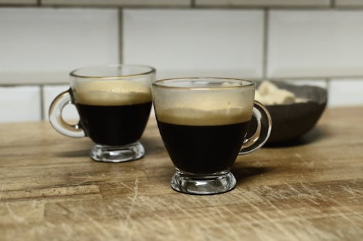 Two glass cups of espresso on a rustic wooden surface, perfect for coffee lovers.