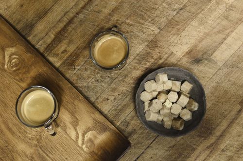Free Two espresso cups and a bowl of sugar cubes on a rustic wooden table. Perfect for coffee themes. Stock Photo