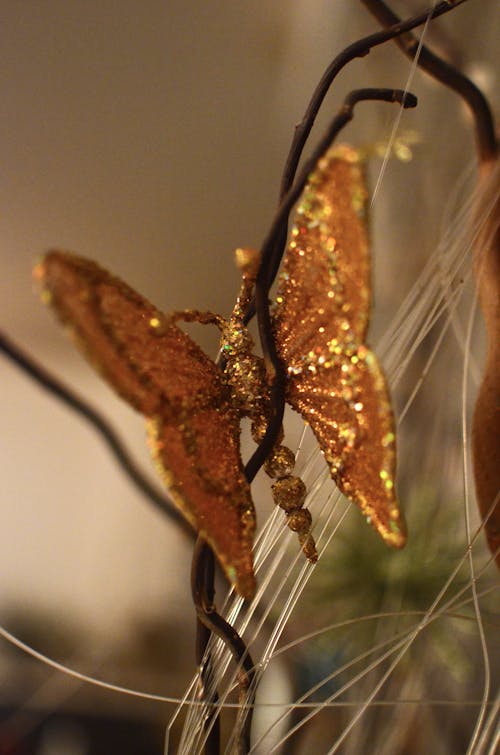 Shiny decorative butterfly on tree branch