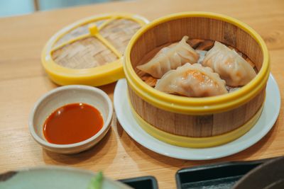 Steamed dumplings in a bamboo basket with chilli dip — photo by FOX on Pexels