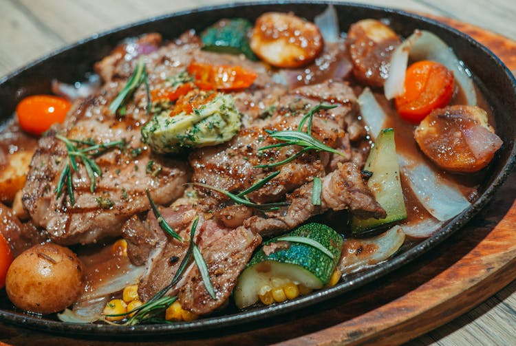 A Close-Up Shot Of Food On A Sizzling Plate