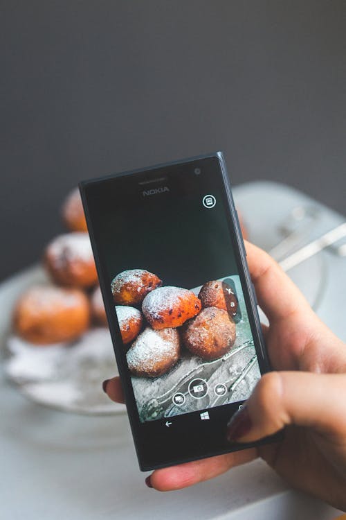 Free Woman hand taking picture of doughnuts Stock Photo