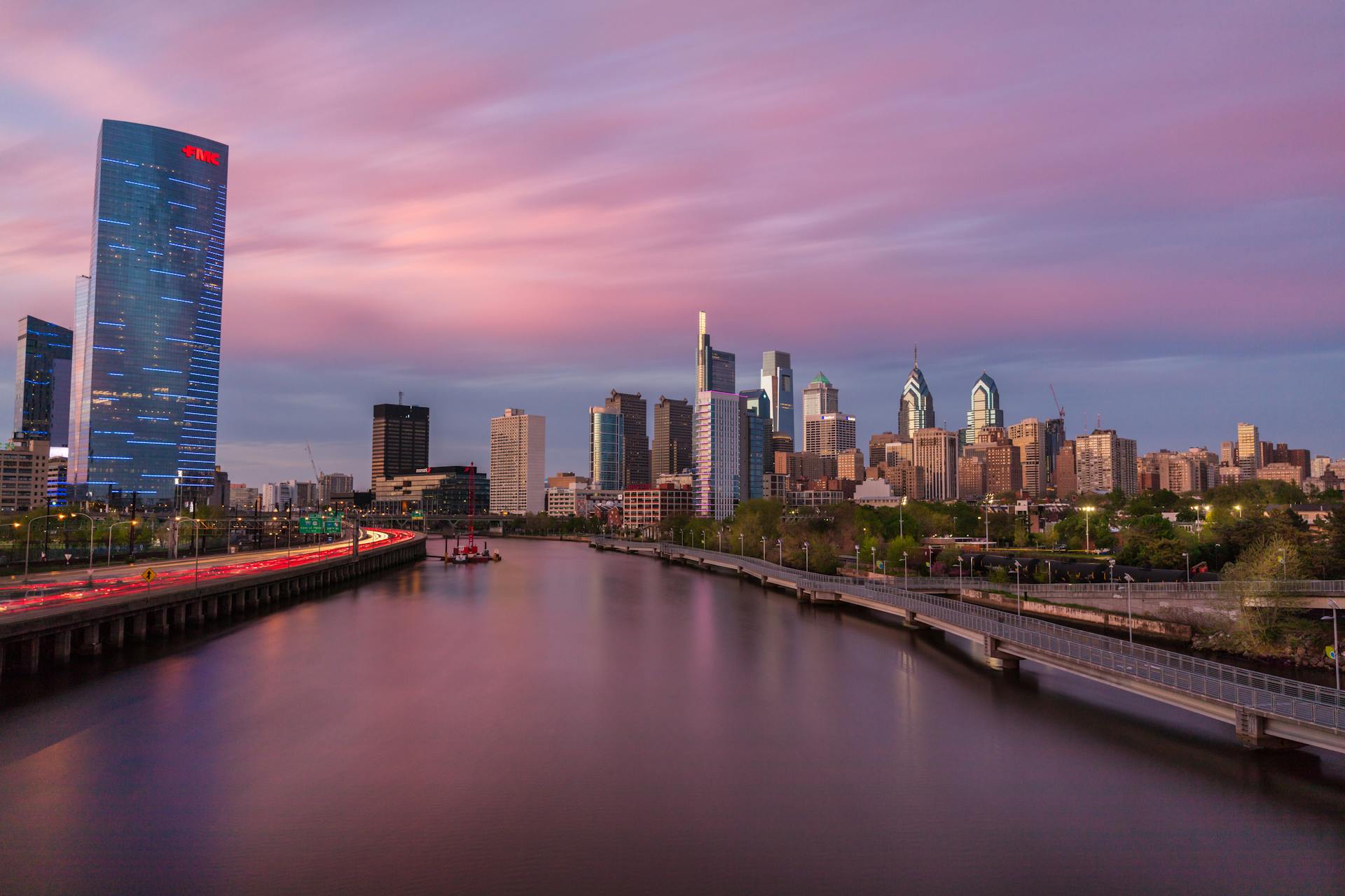 A stunning view of the Philadelphia skyline with a colorful sunset reflecting on the Schuylkill River.