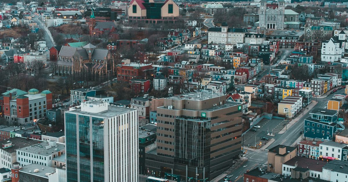 Drone view of modern city with residential buildings and asphalt roads in city in gloomy cold season