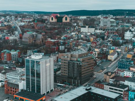 Drone view of modern city with residential buildings and asphalt roads in city in gloomy cold season
