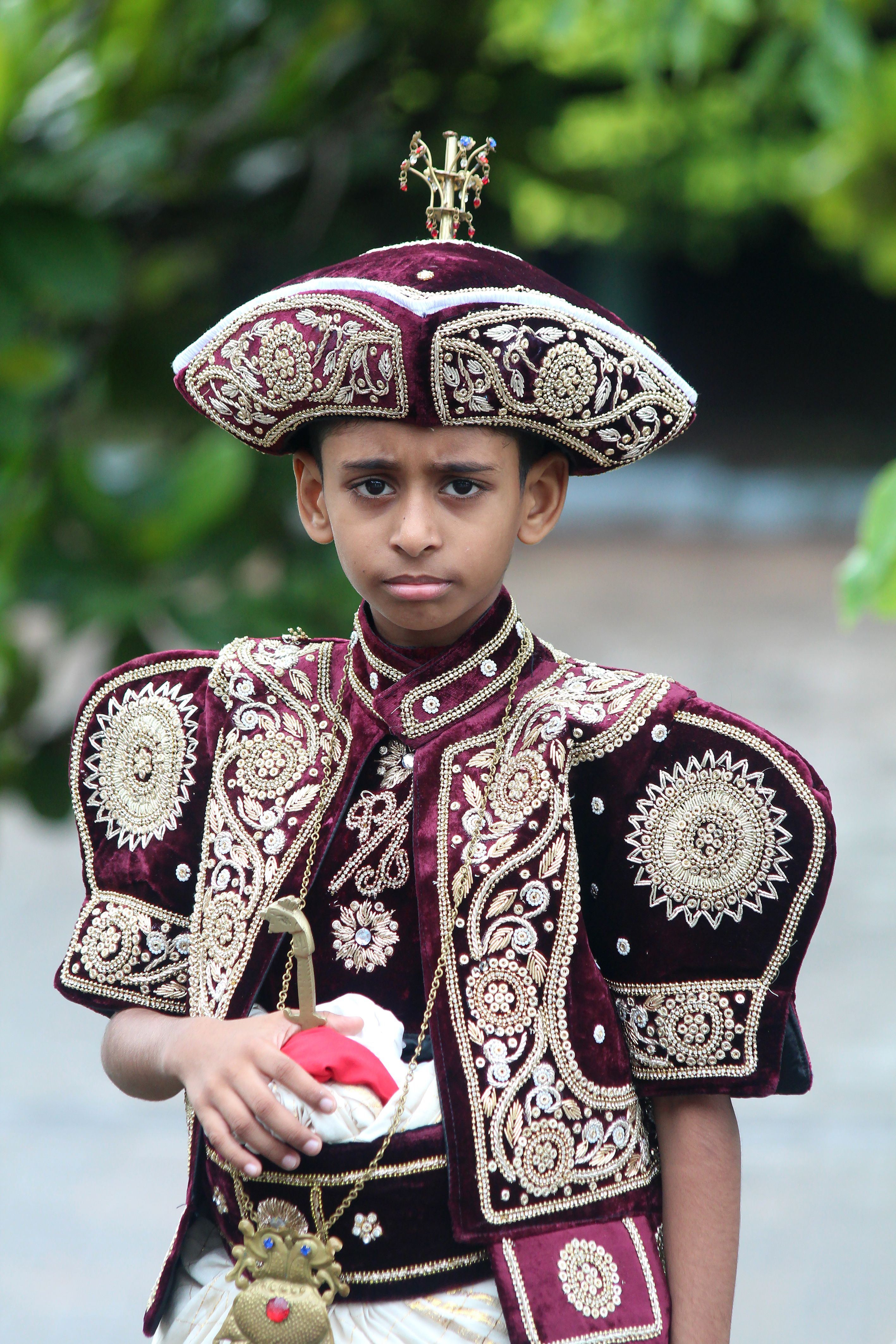 A young boy in elaborate traditional Kandyan attire representing Sri Lankan cultural heritage.