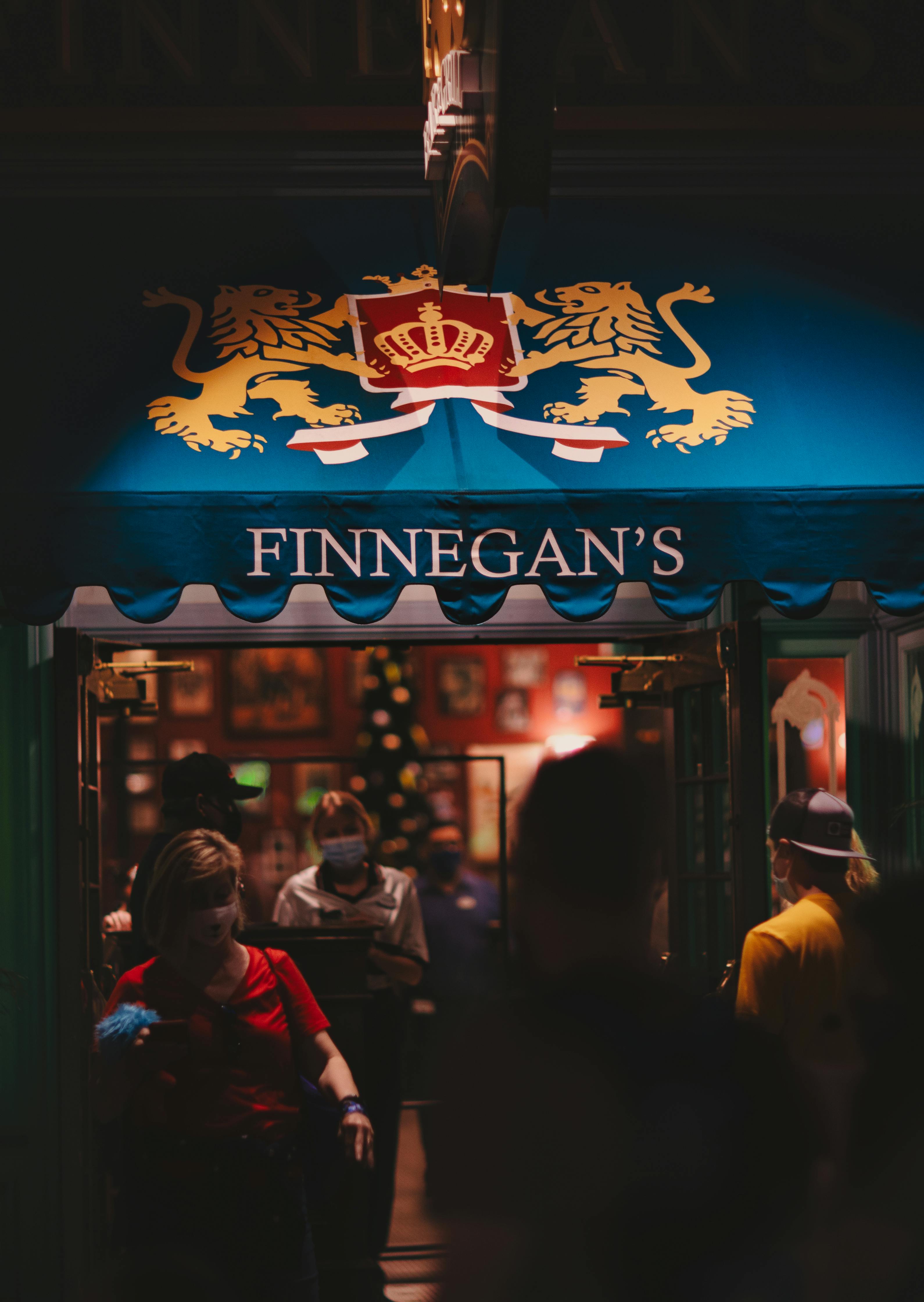 crowded pub entrance with emblem on canopy