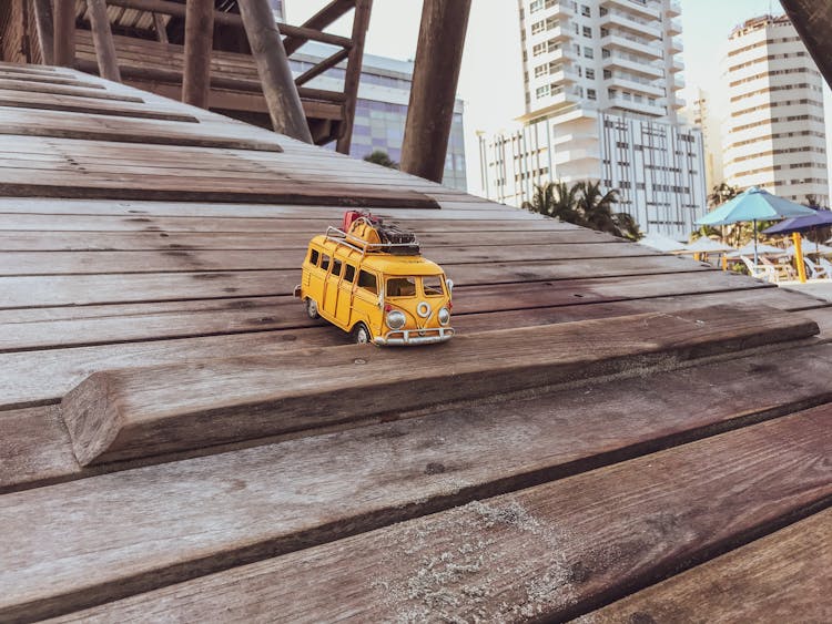 Yellow Toy Car On Brown Wooden Ramp