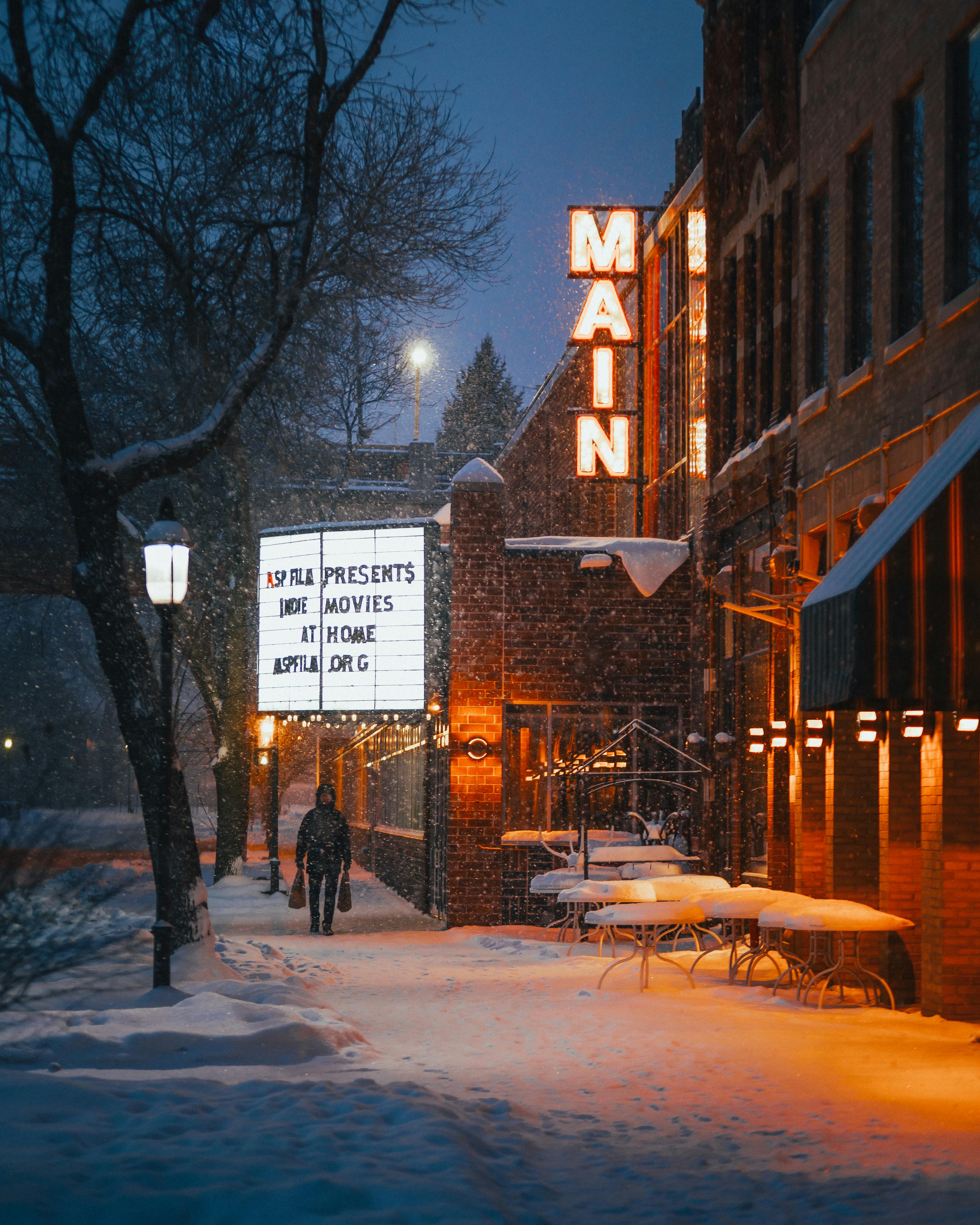 Free A person walks past a snow-covered theater on a winter night in Minneapolis, MN. Stock Photo