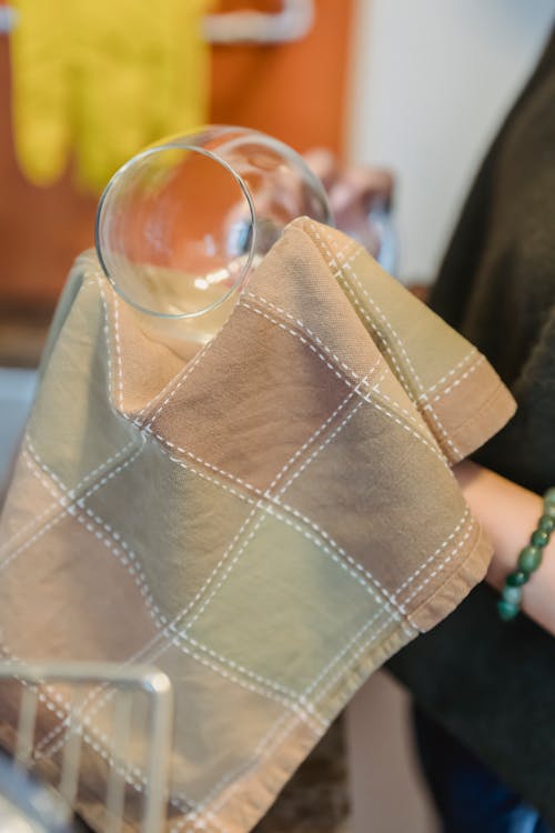 Woman rubbing glasses with checkered towel