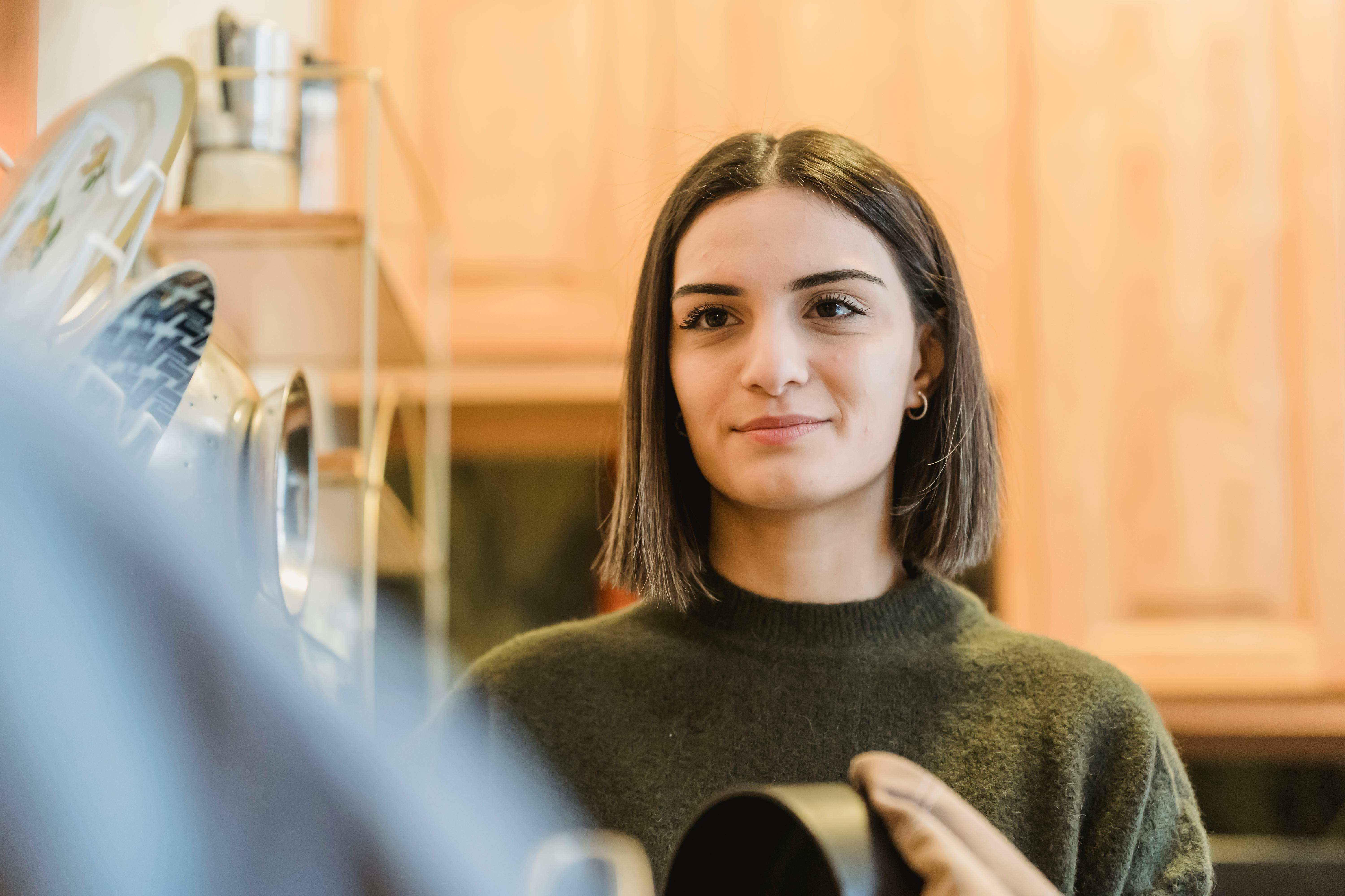 happy smiling woman drying saucepan with towel