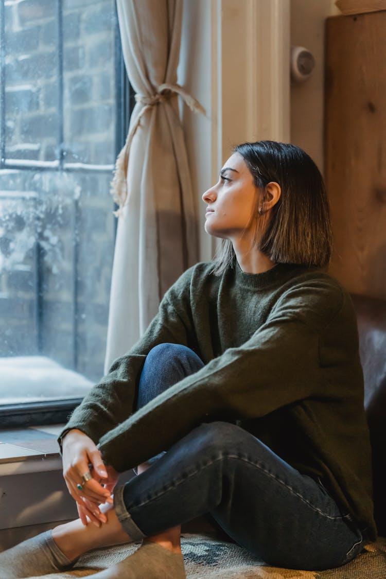 Dreamy Woman With Crossed Legs Sitting Near Window