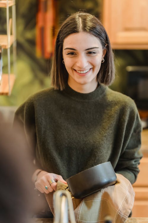 Mulher Sorridente Com Suéter Cinza Segurando Uma Caneca De Cerâmica Preta