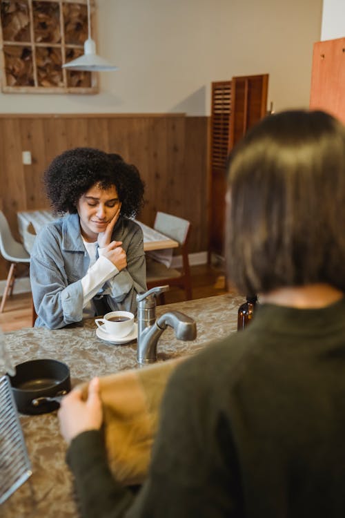 Free Desperate black woman having coffee with friend Stock Photo