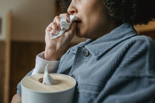 Black crying woman wiping nose with tissue