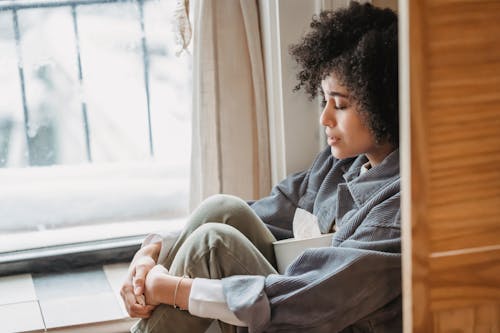 Vrouw In Grijze Trui Zittend Op Een Stoel