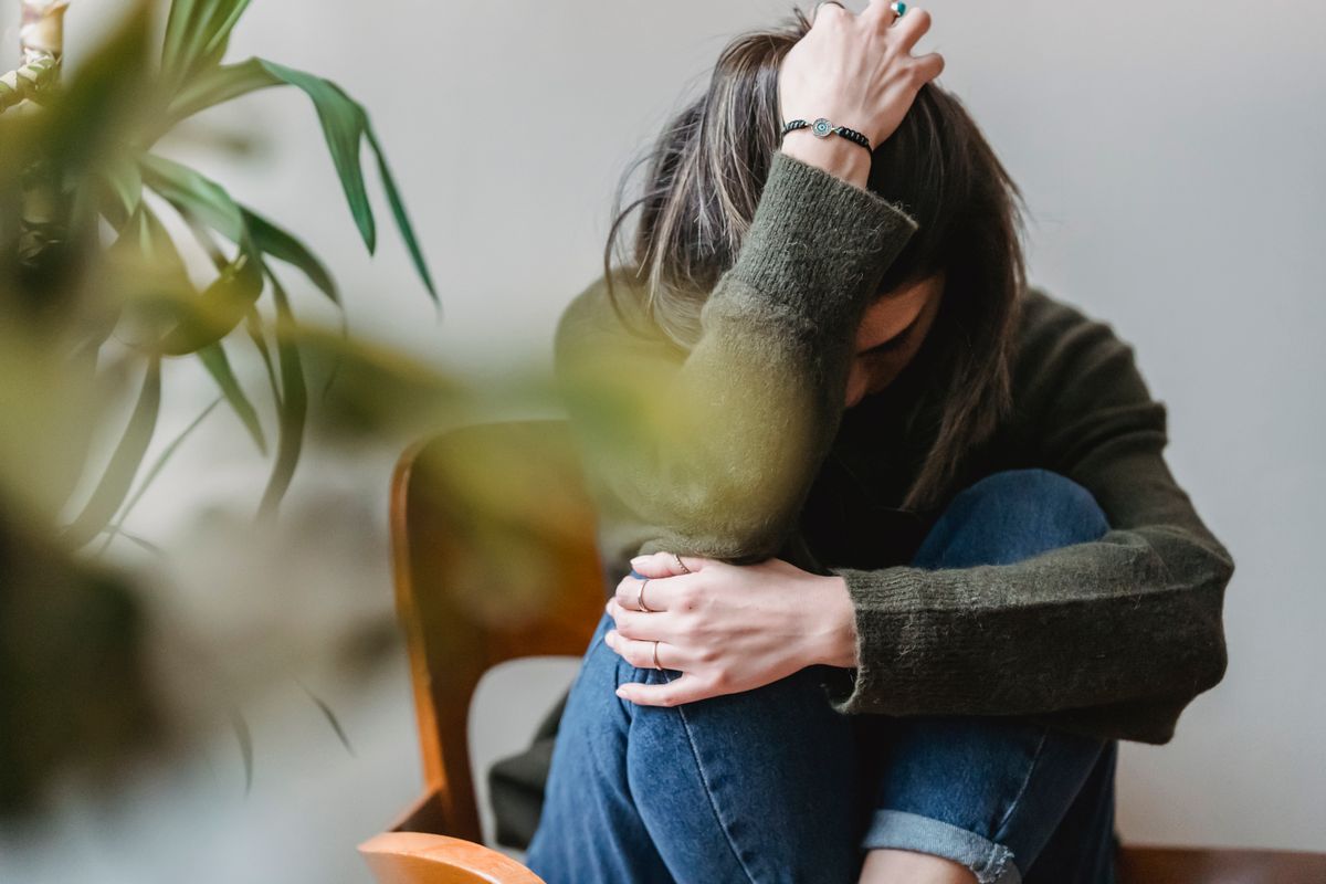 Woman sitting curled and exhausted