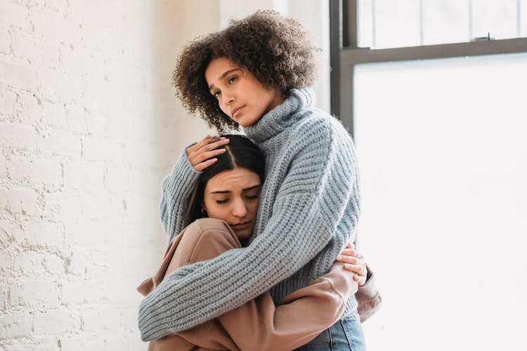 Unhappy Diverse Women Hugging In Room