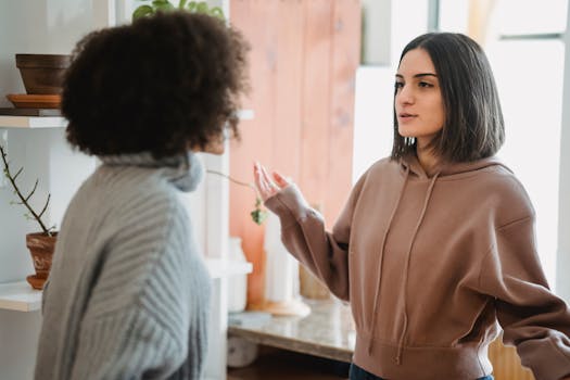 Two women engage in a serious conversation in a cozy indoor setting.