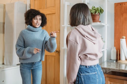 Femme En Pull Gris Et Jeans En Denim Bleu Debout Près De La Porte En Bois Marron