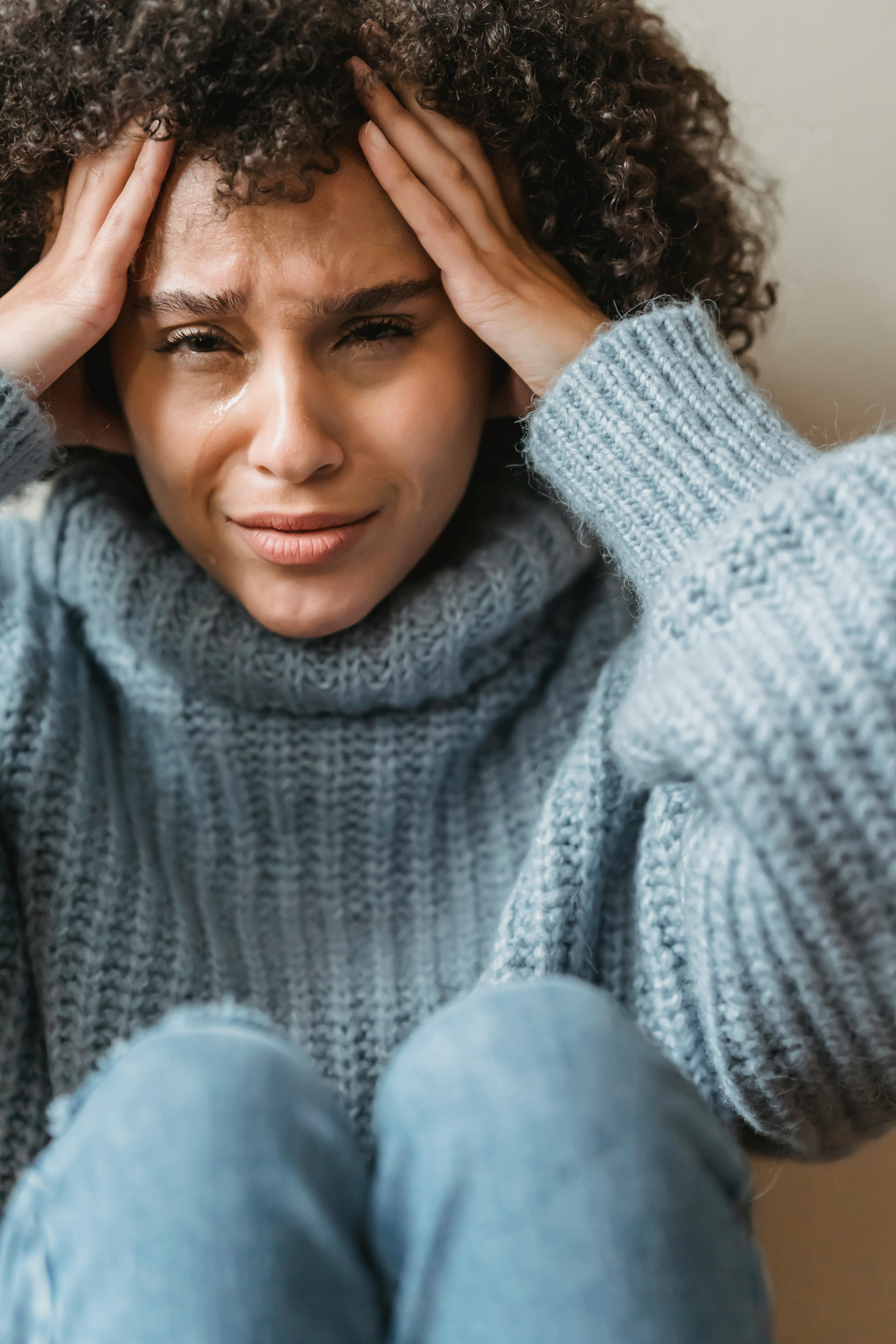 upset black female touching hair and crying