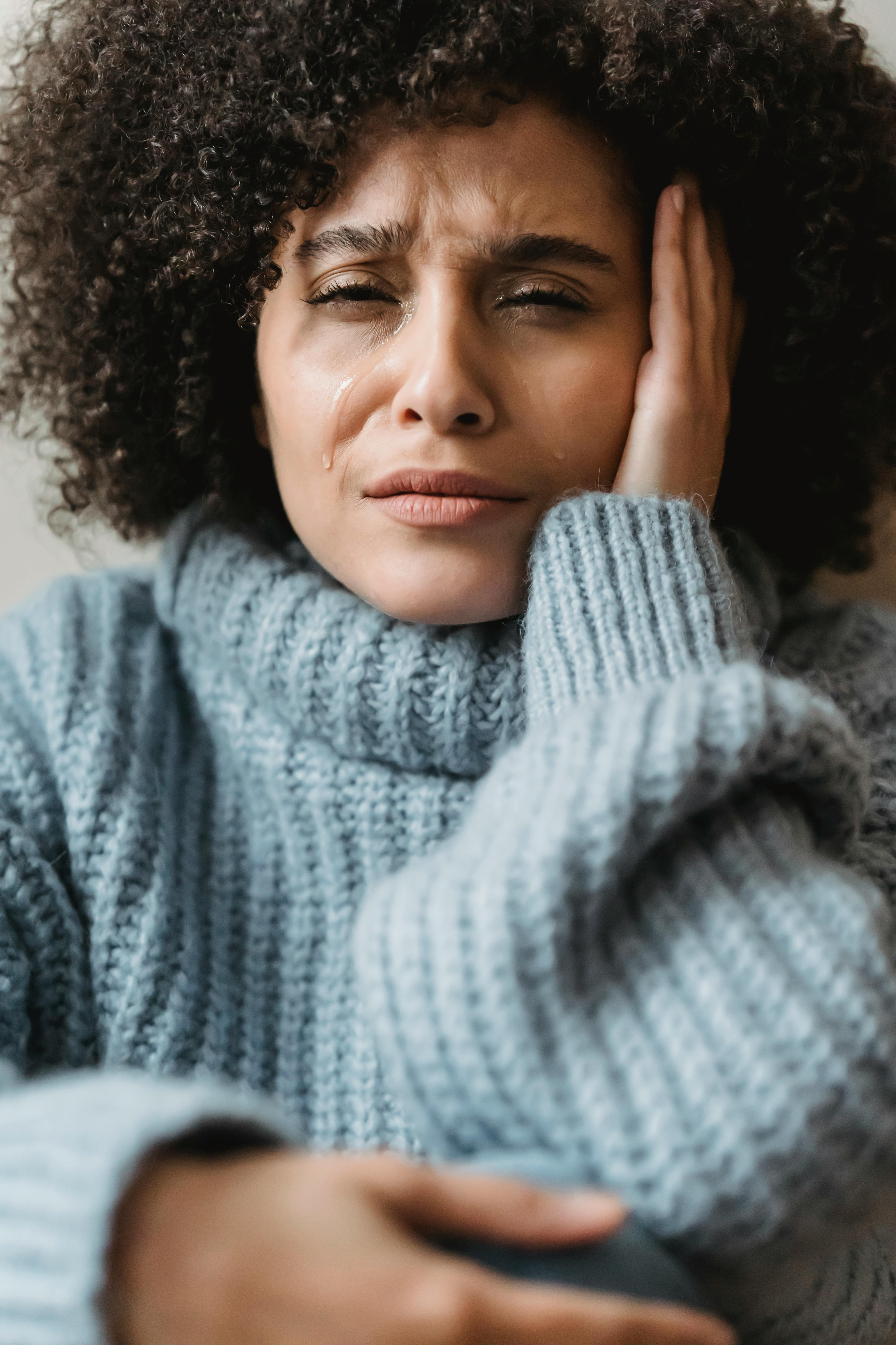 frowning black woman crying and looking at camera