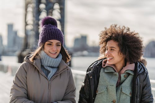 Free Smiling diverse women spending time on winter seafront Stock Photo