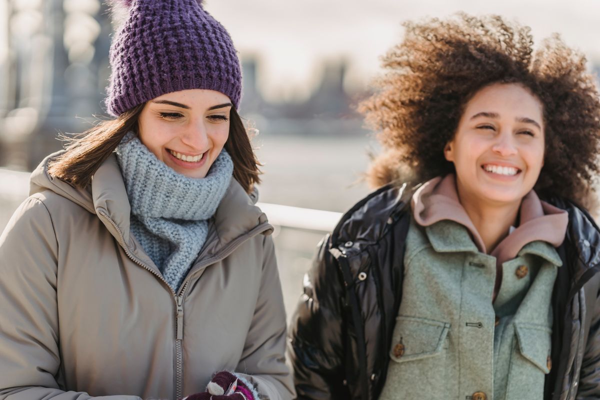 Amigas abrigadas caminando juntas en un día frío