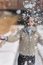 Faceless woman throwing snow in winter park