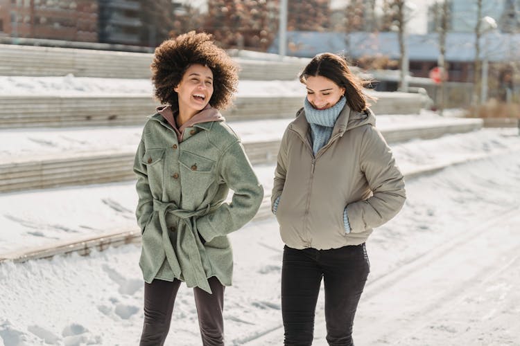 Delighted Diverse Women Strolling On Snowy City Street