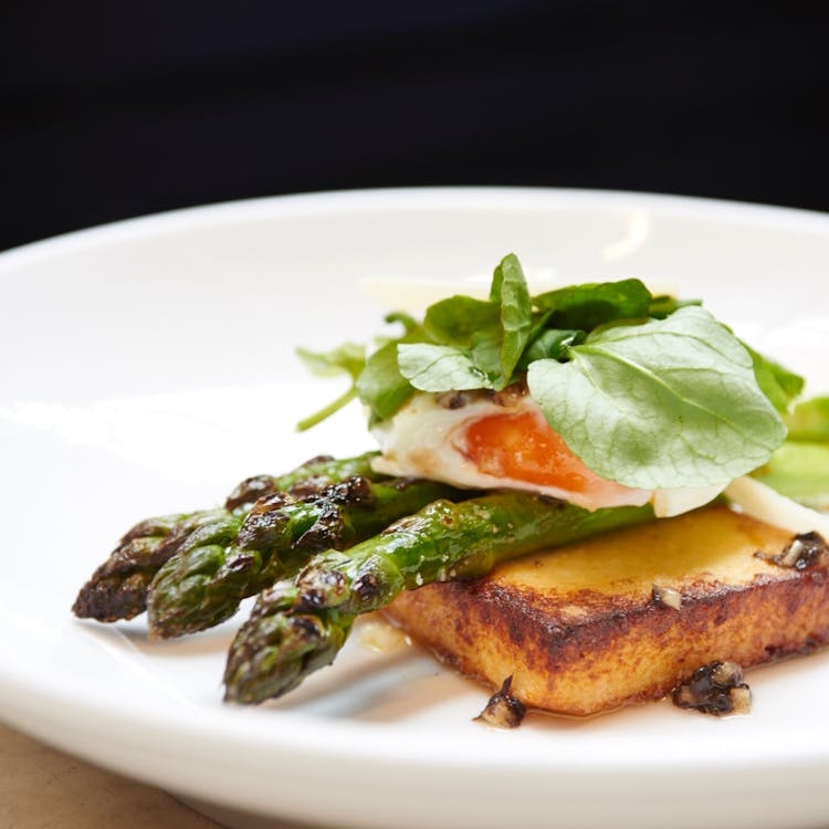 Delicious Toast With Asparagus And Poached Egg Served With Herbs On Plate