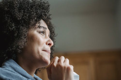 Free Low angle side view of crop depressed young African American female millennial with dark curly hair crying emotionally and looking away Stock Photo