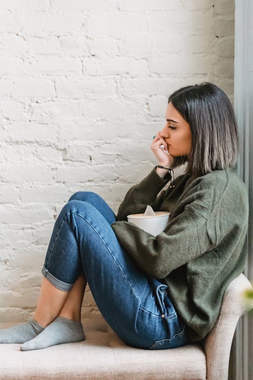 Free Sad woman with tissue box crying on couch Stock Photo