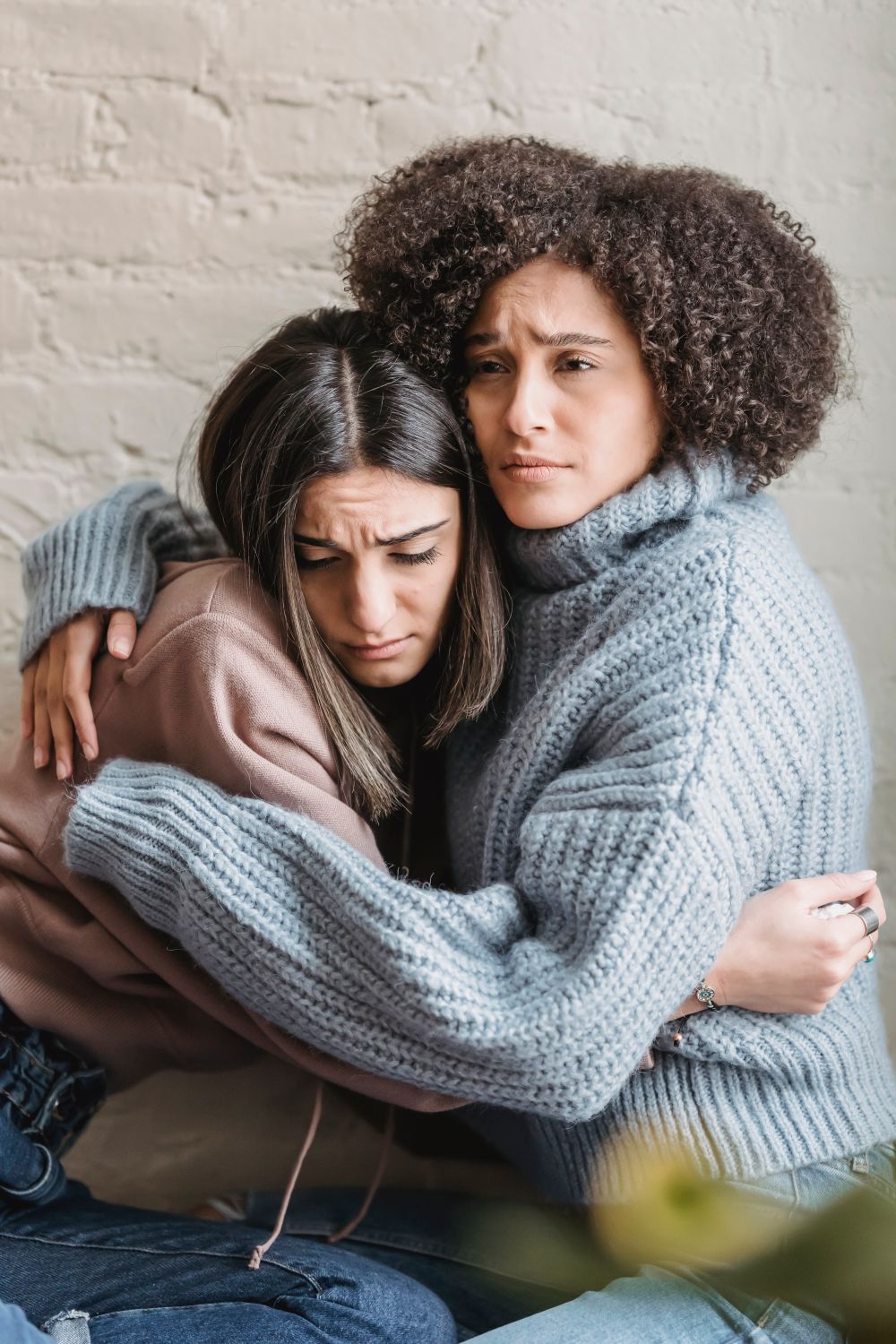 Both Crying Sad multiracial girlfriends crying while hugging each other in room ...