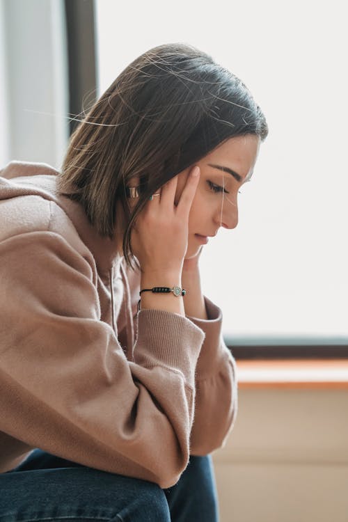 https://www.pexels.com/photo/sad-woman-with-hands-on-head-in-room-6383189/