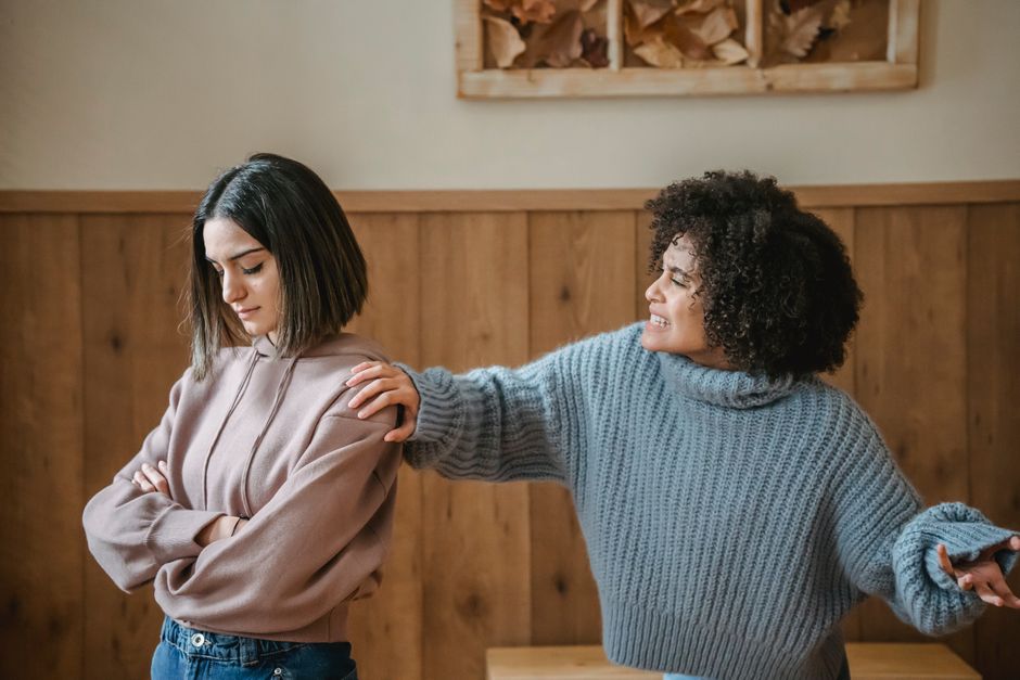 Photo by Liza Summer on Pexels Unhappy young multiethnic female friends in casual outfit arguing with hand on shoulder while standing in bright house near wall - Photo by Liza Summer on Pexels
