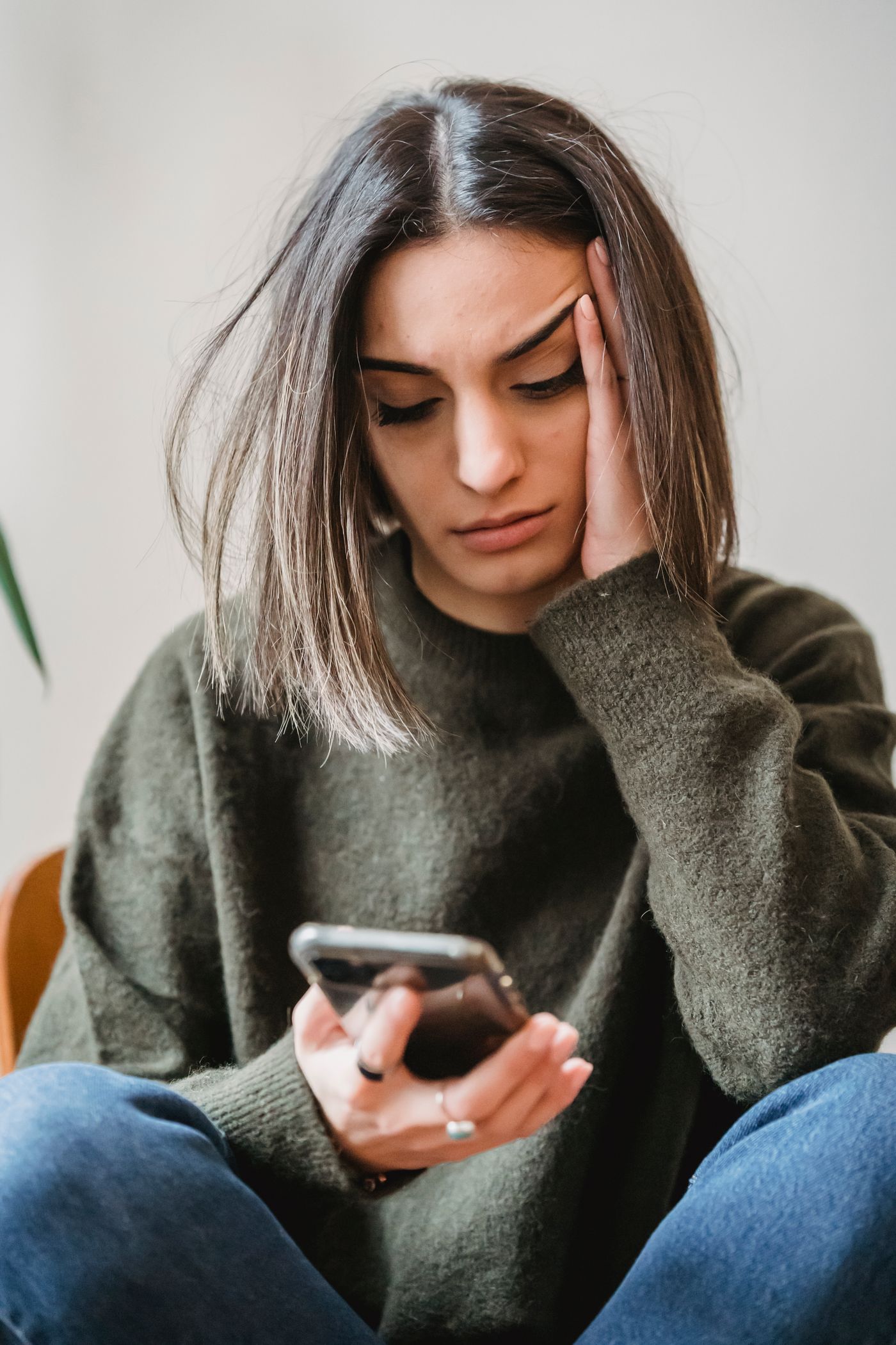 امرأة قلقة تتصفح هاتفها بانزعاج