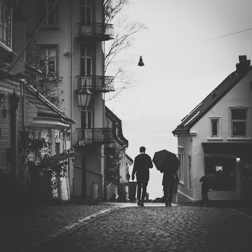 Grijstinten Foto Van Man Naast Vrouw Onder Paraplu Lopen Op Stoep