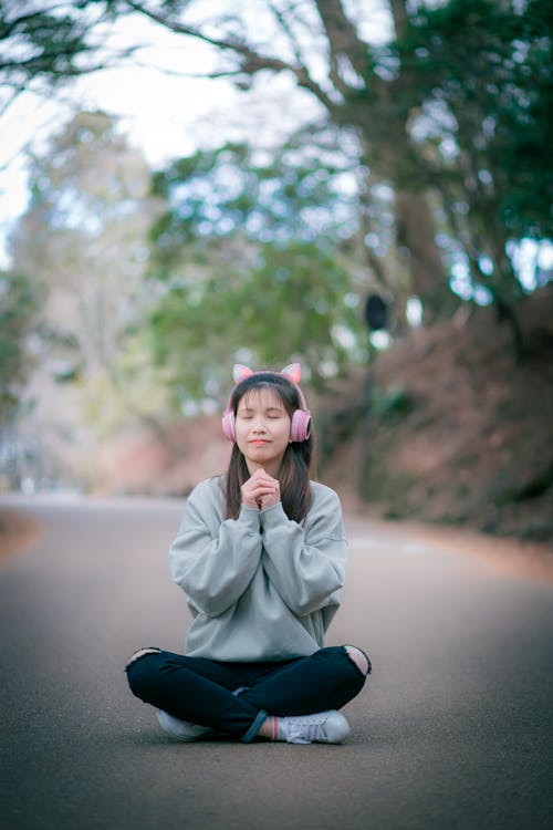 Foto d'estoc gratuïta de asiàtica, assegut, auriculars de color rosa