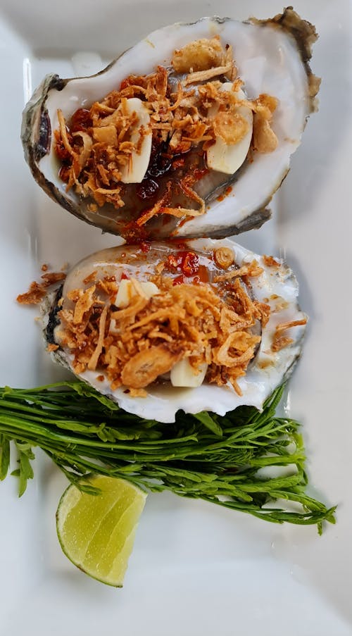 Free A Delicious Clam Topped with Fried Garlic on a White Dish Plate Stock Photo