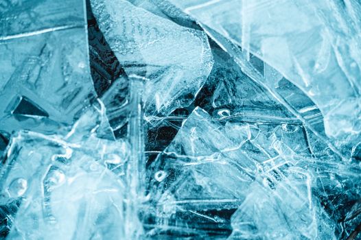 High angle of crystal frozen water with cracks and broken thin ice pieces in daylight