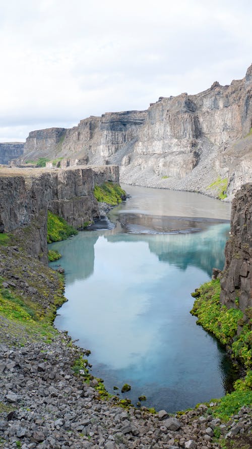 A Lake Between Brown Cliffs