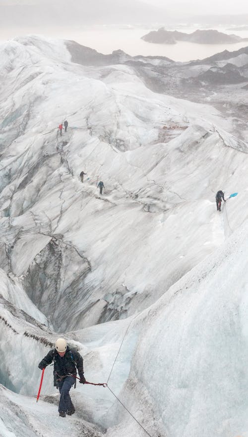 People Hiking the Snow Covered Mountain
