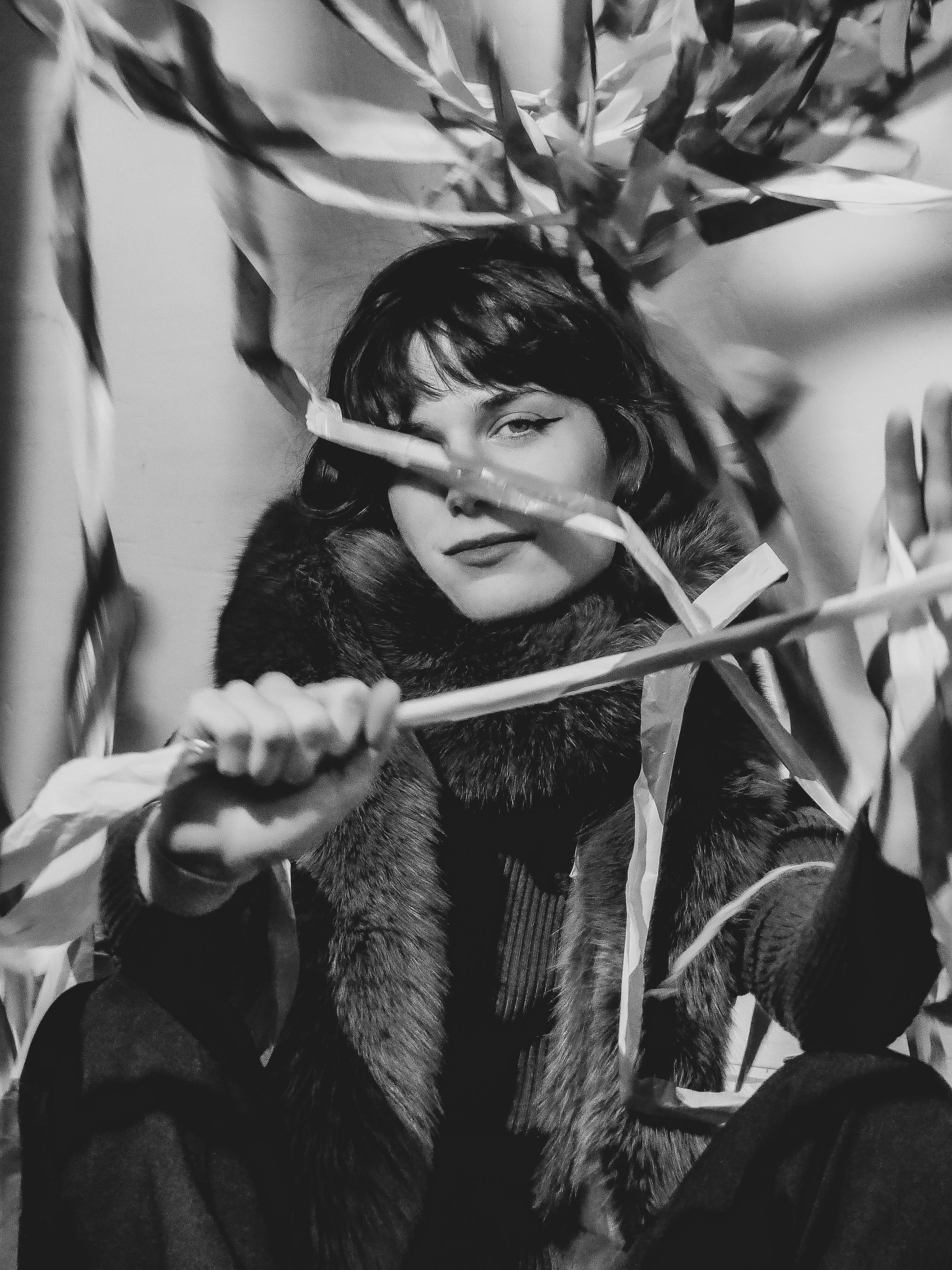 Free Black and white artistic portrait of a woman with ribbons adding a dynamic touch, exuding elegance and creativity. Stock Photo