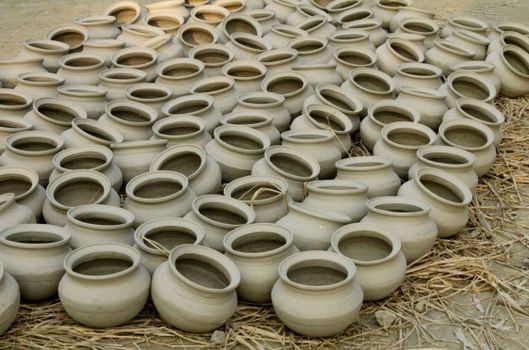 An array of handmade clay pots drying outdoors in Bangladesh, showcasing traditional craftsmanship.