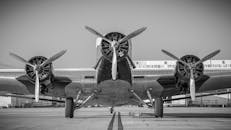 一张黑白照片展示了一架带有三个螺旋桨的老式飞机，呈现了经典的航空工程