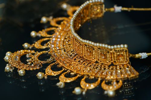 Free Close-up of a stunning gold choker necklace adorned with pearls, showcasing intricate craftsmanship. Stock Photo