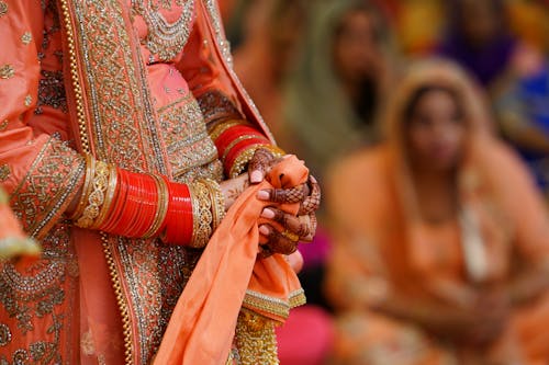 Crop unrecognizable Indian bride in traditional fancy gown